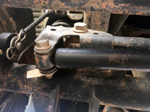 The OEM stabilizer shock is held on by bolts at the track bar bracket and a stud attached to the tie rod.